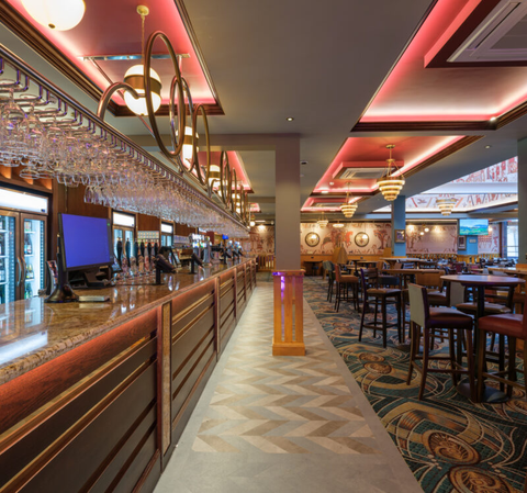 Warmly lit pub bar with brass details and dining area